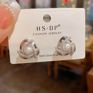 Detailed close-up of S925 silver stud earrings with spiral pearl and zircon design