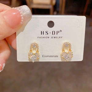 Macro detail of gold plated heart stud earrings with cubic zirconia and pave diamonds