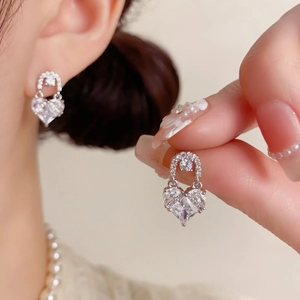 Detail of silver heart earrings featuring micro-pave crystals and large heart zircon stones