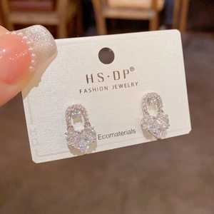 Close-up of heart-shaped silver stud earrings with sparkling pavé cubic zirconia inlay