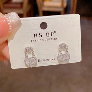 Macro view of exquisite gold-plated heart stud earrings with sparkling rhinestones