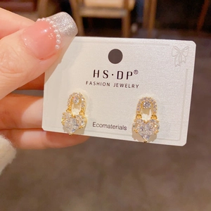 Macro detail of gold plated heart stud earrings set with sparkling zircon stones