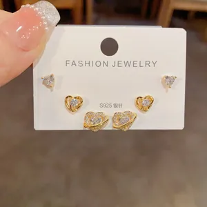 Détails d'un ensemble de trois paires de boucles d'oreilles cœur et planète en zircon