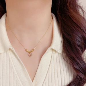 Élégant collier cœur doré avec pierre rose et pavé de diamants sur un modèle