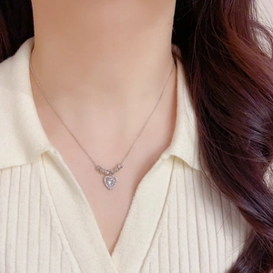 Détail du collier pendentif cœur argenté avec cristaux étincelants porté sur un mannequin