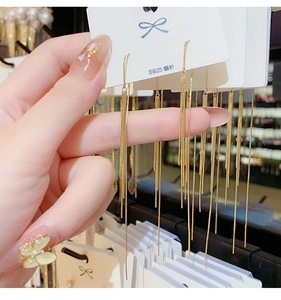 Macro shot showing long gold fringe chain earrings with S925 silver needles detail