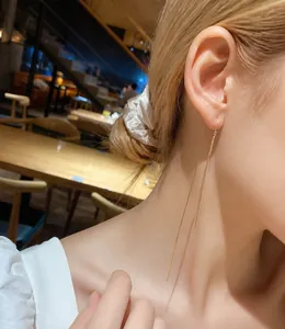 Elegant long gold chain tassel earrings shown on model for a stylish dangling jewelry look