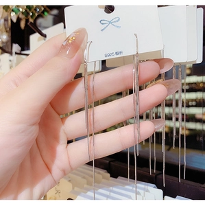 Detail of long chain tassel earrings featuring silver metallic fringe and S925 needle