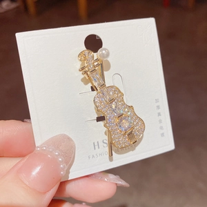 Elegant gold plated violin brooch with sparkling crystals and a white pearl accent