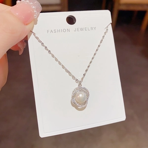 Elegant silver freshwater pearl necklace with zircon-encrusted rings on a display card