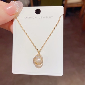 Elegant freshwater pearl necklace with zircon-encrusted spiral frame on golden chain