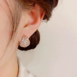 Nahaufnahme glitzernder silberner Tropfenohrringe mit Kristallen am Ohr