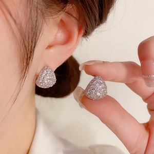 Makroaufnahme eines tropfenförmigen Silberohrrings mit funkelnden Pavé-Zirkonia-Steinen