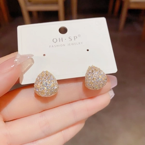 Makroaufnahme von silbernen Tropfenohrringen mit Zirkonia auf goldenem Sockel