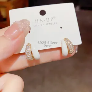 Detailed macro view of gold-plated earring with zircons and S925 silver needle hallmark
