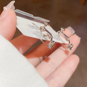 Detail view of silver screw-back clip-on earrings with comfortable silicone pads