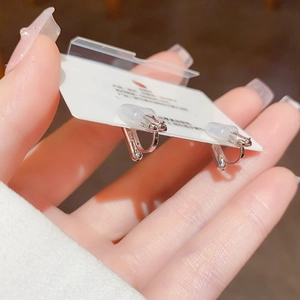 Detailed view of silver U-shaped metal ear clips with silicone pads for non-pierced ears