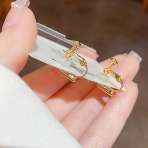 Close-up of gold screw-back clip-on earrings with silicone pads for non-pierced ears