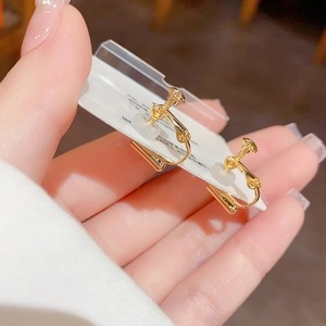 Detail of gold spiral ear clips with transparent silicone pads for non-pierced ears