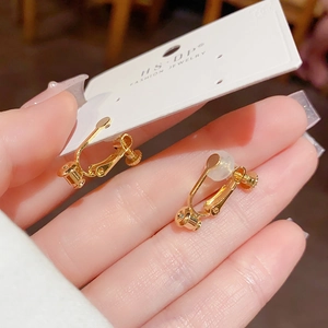 Detail showing the adjustable screw-on golden clip earrings with clear silicone pads