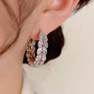 Close-up of sparkling marquise-cut zircon hoop earrings worn by a model in silver finish