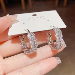 Macro detail of silver wheat-ear hoop earrings with marquise-cut cubic zirconia