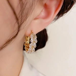 Macro detail of gold wheat ear hoop earrings with marquise-cut marquise cubic zirconia