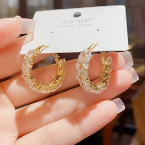 Close-up of gold wheat hoop earrings with marquise-cut zircons on a display card