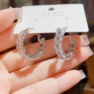Detailed close-up of silver hoop earrings with marquise-cut zircon on a white card