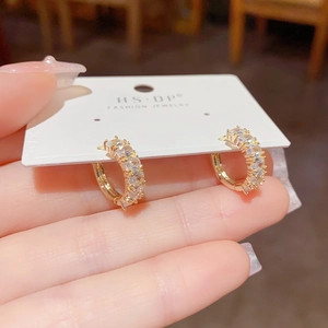 Detailed view of dainty gold-plated hoop earrings with shimmering pavé zircon stones