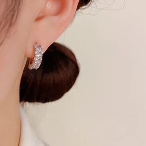 Exquisite small hoop earrings with pavé zircons in rose gold worn by a model