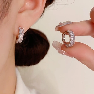 Macro detail of silver hoop earrings featuring micro-pave sparkling cubic zirconia stones