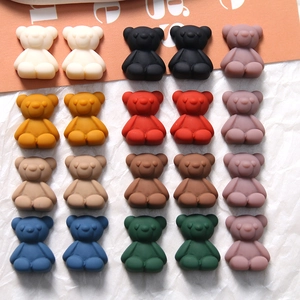 Flat lay of small matte resin cartoon bears for DIY jewelry and phone case making