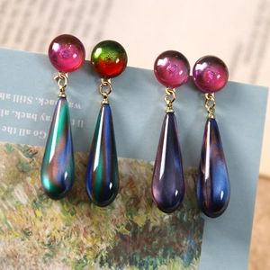 Detailed macro view of 3D quicksand effect resin teardrop charms for jewelry making
