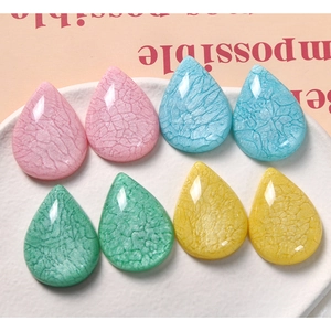 Detailed macro view of teardrop resin charms with internal crackle texture for DIY jewelry