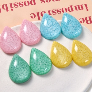 Detail of tear-drop resin beads with pearl crackle finish and faceted edges for DIY crafts