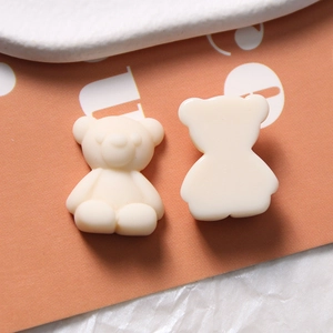 Detailed macro view of matte cream resin bear charms for DIY jewelry and crafts