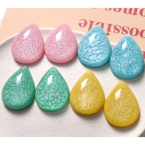 Detailed close-up of water drop resin accessories with cracked texture and faceted surface