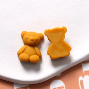 Macro view of matte ginger resin bear charms showing front and flat back for DIY crafts