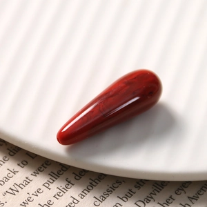 Macro shot of dark red marble resin teardrop pendant with pre-drilled hole for DIY jewelry