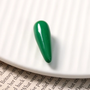 Macro shot of a dark green resin teardrop pendant with a glossy finish and a tiny hole