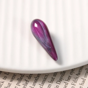 Macro shot of purple cat-eye resin teardrop pendant with shimmering starry effect