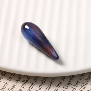 Macro detail of teardrop resin pendant with deep blue starry sand marble texture