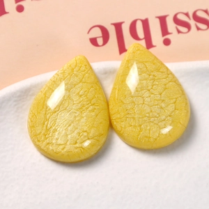 Close-up of bright yellow resin water drop pendants with distinctive crackle texture