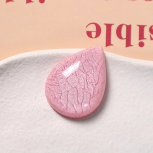 Macro detail of translucent pink teardrop resin charm with unique crackle texture