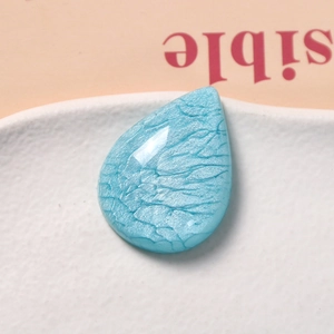Macro shot of sky blue teardrop resin pendant with unique marble smoke texture for DIY