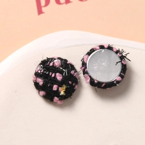 Makroaufnahme der rosa-schwarzen Tweed-Rundknöpfe mit Silberfäden für DIY-Nähprojekte