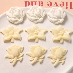 Detailed macro view of 3D resin daisy and rose floral charms for DIY accessories