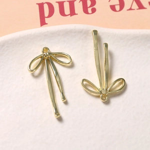 Detail van twee gouden metalen strikhangers met ophanglussen voor doe-het-zelf sieraden