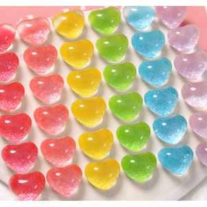 Dettaglio macro di ciondoli a cuore in resina glitterata per gioielli fai-da-te